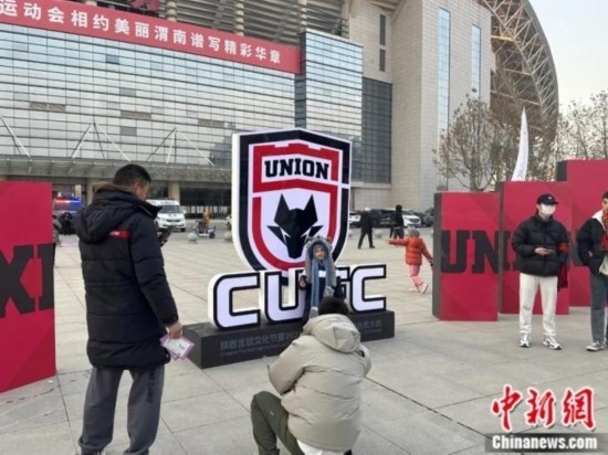 球迷們與隊(duì)徽合影。記者 卞立群 攝