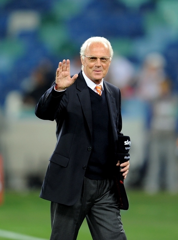 這是2010年7月7日，在南非德班舉行的2010年足球世界杯德國隊對陣西班牙隊的半決賽前，貝肯鮑爾接受電視臺采訪時和友人打招呼。新華社記者 王毓國 攝