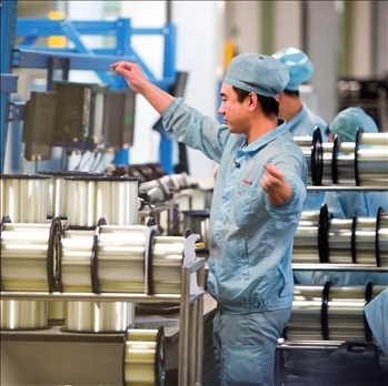 在位于武漢的長(zhǎng)飛光纖光纜股份有限公司光纖生產(chǎn)車間內(nèi)，工作人員對(duì)光纖進(jìn)行檢測(cè)（資料圖片）。肖藝九攝/本刊