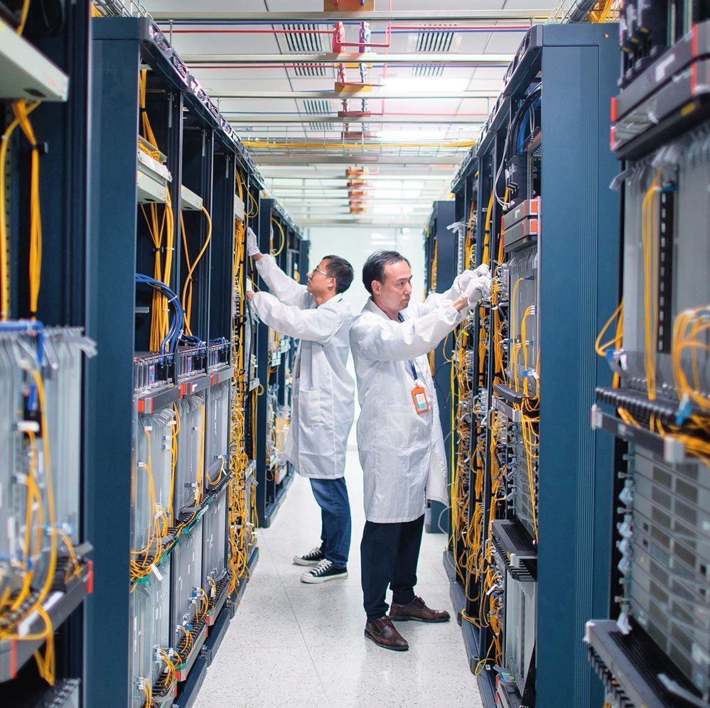 在位于武漢中國(guó)光谷的光電器件研發(fā)制造商——武漢光迅科技股份有限公司生產(chǎn)車間內(nèi)，技術(shù)人員在光模塊生產(chǎn)線作業(yè)（2023年4月11日攝）。程敏攝/本刊