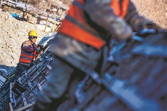 1月3日，房山區(qū)，工人正在雙泉河修筑堤壩。