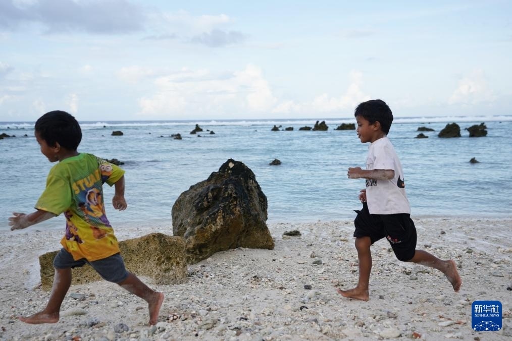 1月20日，兒童在瑙魯海邊嬉戲。新華社記者 王申 攝