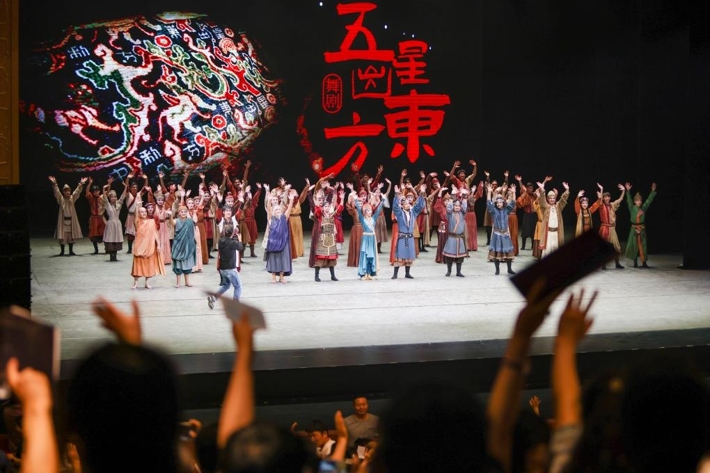 2023年7月31日，新疆和田地區(qū)新玉歌舞團(tuán)在烏魯木齊京劇院演出舞劇《五星出東方》后和觀眾互相揮手致意。這場(chǎng)演出是第六屆中國(guó)新疆國(guó)際民族舞蹈節(jié)的參演劇目之一，曾榮獲國(guó)家“文華獎(jiǎng)”等。新華社記者 郝昭 攝