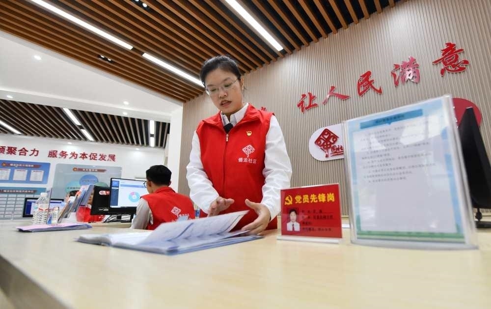 △2023年12月14日，廣西南寧市蟠龍社區(qū)，工作人員在為居民服務(wù)。