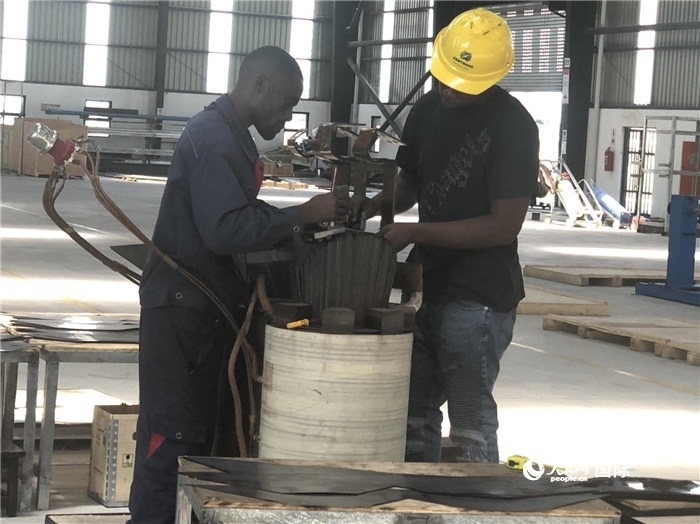 經(jīng)貿(mào)合作區(qū)廠房內(nèi)，當(dāng)?shù)毓と苏诰o張作業(yè)。人民網(wǎng)記者 黃培昭攝