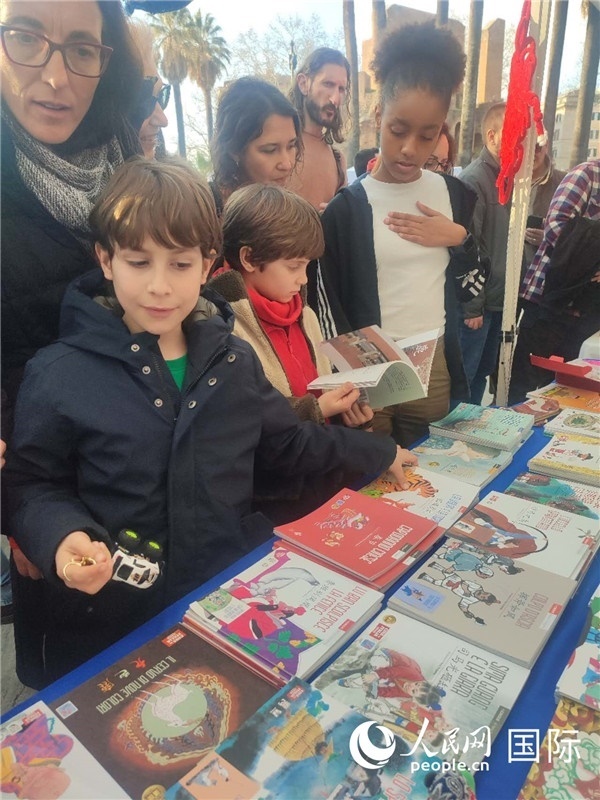 印刷精美的中國(guó)傳統(tǒng)文化叢書吸引了小游客的注意。人民網(wǎng)記者鄭彬攝