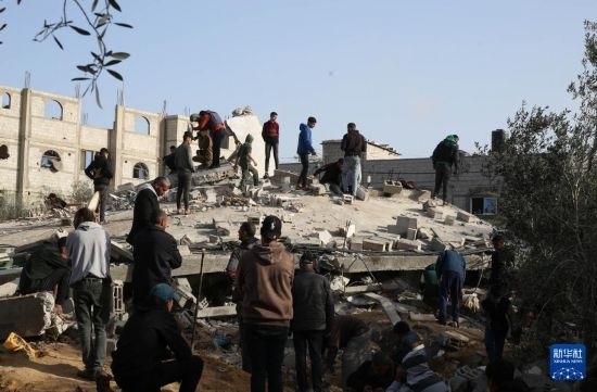  3月3日，在加沙地帶南部城市拉法，人們查看被以軍空襲破壞的建筑。新華社發(fā)（哈立德·奧馬爾攝）