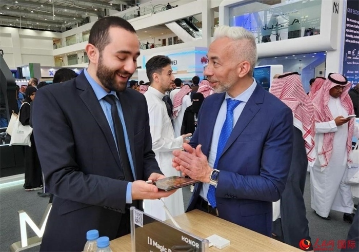 兩名觀眾在榮耀手機(jī)展臺(tái)前交流。人民網(wǎng)記者 管克江攝