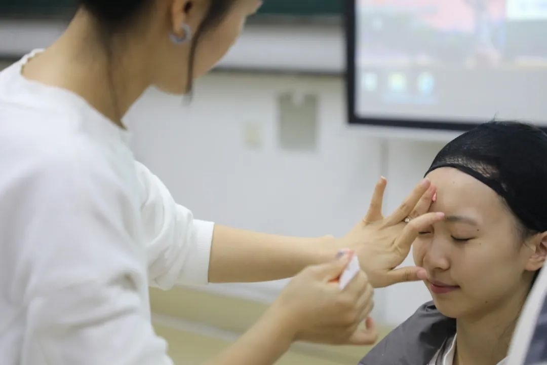 課堂上，一名學(xué)生在體驗上戲妝。學(xué)校供圖