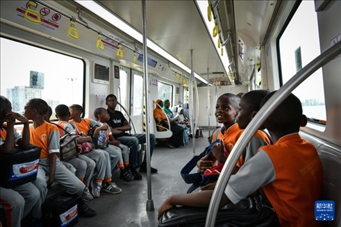 2月28日，在尼日利亞拉各斯，一所小學(xué)的學(xué)生們體驗(yàn)乘坐輕軌藍(lán)線列車(chē)。新華社記者 韓旭 攝