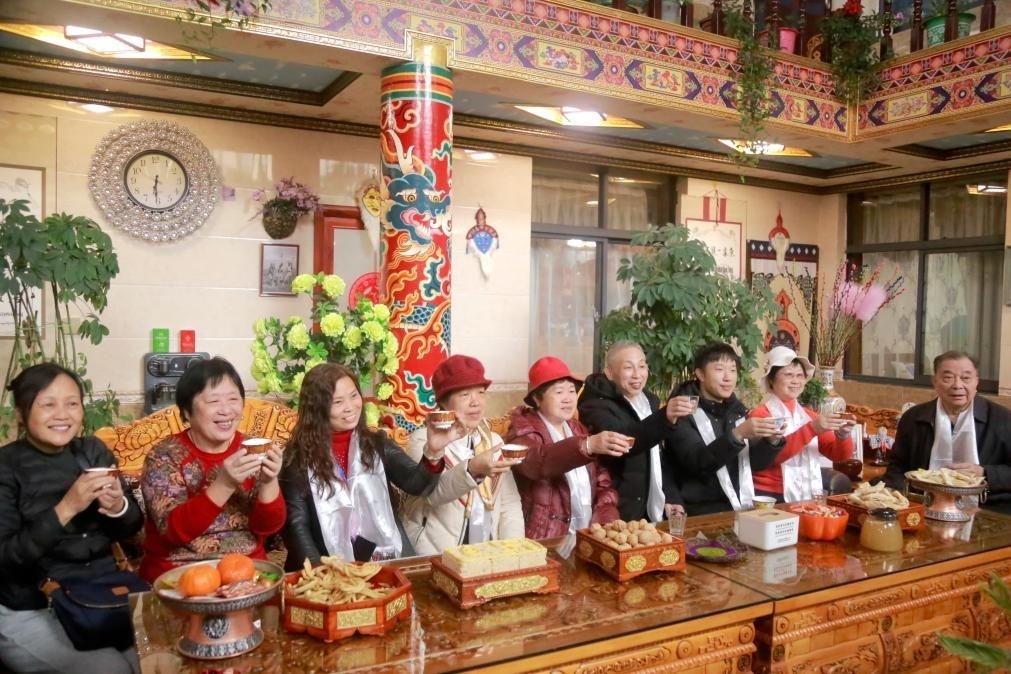 游客們?nèi)胱∶袼藓?，舉杯共飲酥油茶。新華社記者 邱星翔 攝