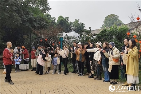 葉科（左一）給前來(lái)參與活動(dòng)的“柑爸柑媽”介紹生態(tài)種植果。人民網(wǎng)記者朱虹攝