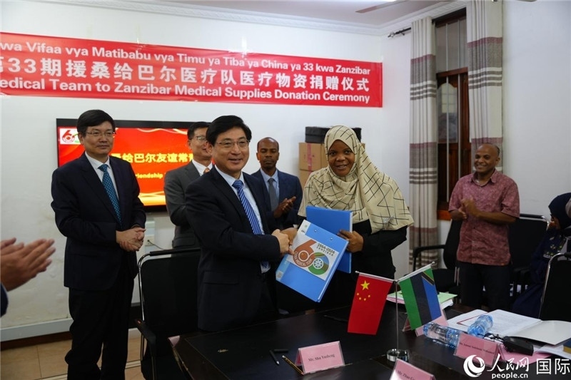 江蘇省蘇北人民醫(yī)院黨委書記束余聲與桑衛(wèi)生部首席秘書哈比巴交換捐贈書。中國援桑醫(yī)療隊供圖