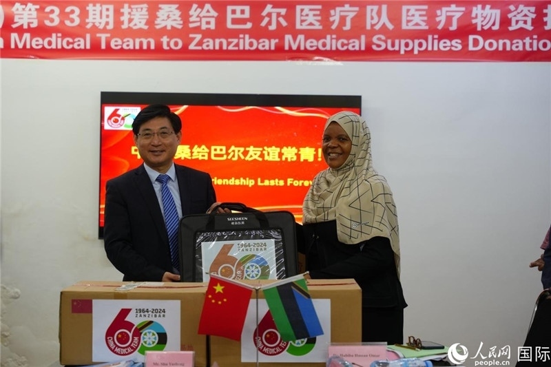 江蘇省蘇北人民醫(yī)院黨委書記束余聲捐贈物資與桑衛(wèi)生部首席秘書哈比巴。中國援桑醫(yī)療隊供圖