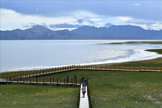 △ 游客行走在青?，敹嗫h冬格措納湖畔的木棧道上。