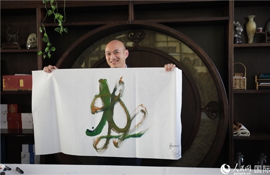 老撾駐華大使館三秘明君參加《五百筆·瀾湄合作》集體藝術(shù)創(chuàng)作。人民網(wǎng)王婧攝。