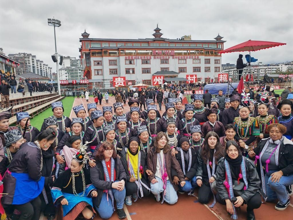 法國青年在“村超”賽場邊與參加表演的村民合影。新華社記者 羅羽 攝