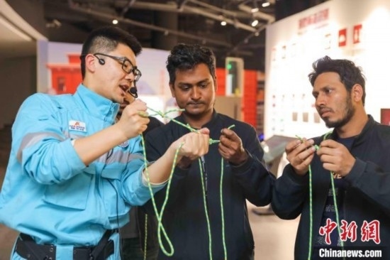 5月9日，工作人員指導(dǎo)留學(xué)生學(xué)習(xí)打繩結(jié)。張鷹 攝