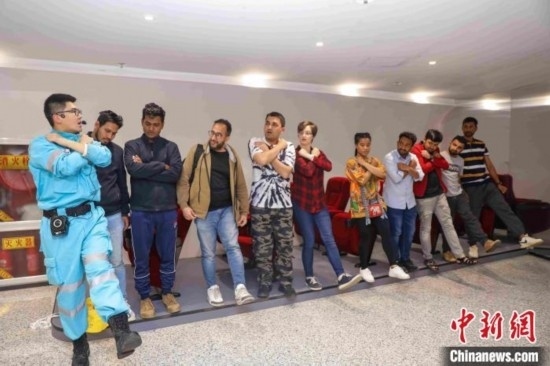 5月9日，工作人員指導(dǎo)留學(xué)生練習(xí)逃生技巧。張鷹 攝