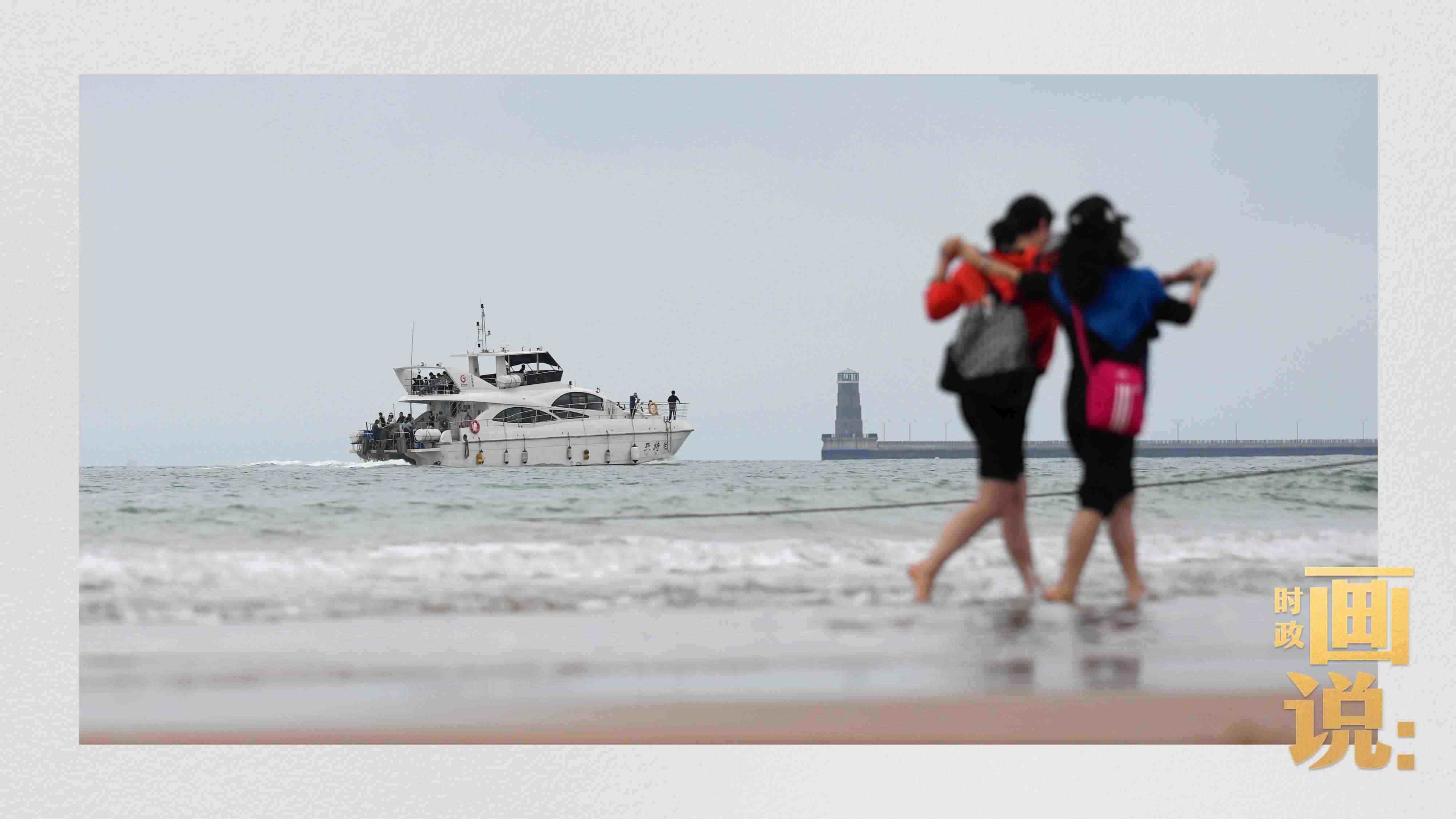 △日照陽光海岸綠道上的萬平口景區(qū)，一對(duì)游客在海浪中翩然起舞。