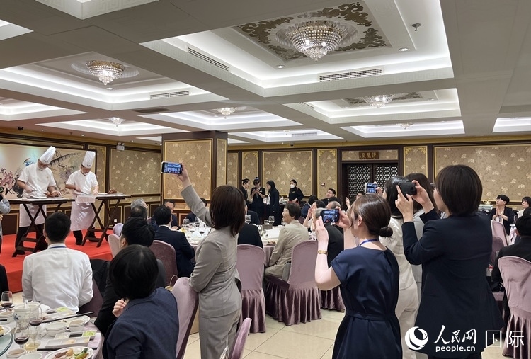 國家級非物質文化遺產、全聚德片鴨工藝吸引代表團成員拍照留念。