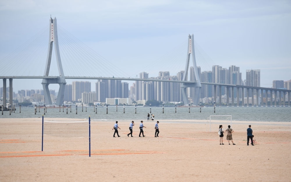 2023年7月17日，廣東湛江五環(huán)廣場(chǎng)的沙灘上，公安民警在執(zhí)勤巡邏。新華社記者 鄧華 攝
