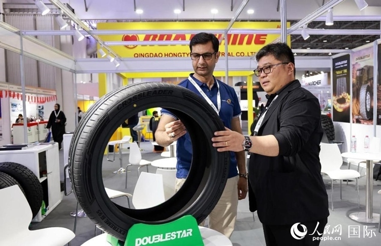 工作人員向客戶展示雙星電動(dòng)汽車輪胎。和傳統(tǒng)汽車輪胎相比，電動(dòng)汽車輪胎具有更高承載能力、更加靜音舒適、更好極速抓地、更低滾動(dòng)阻力等特點(diǎn)。人民網(wǎng)記者 管克江攝