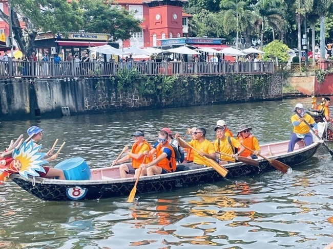 多元種族共同奮輯前進(jìn)，體驗(yàn)在馬六甲河劃龍舟，引來(lái)大批游客駐足圍觀。組委會(huì)供圖