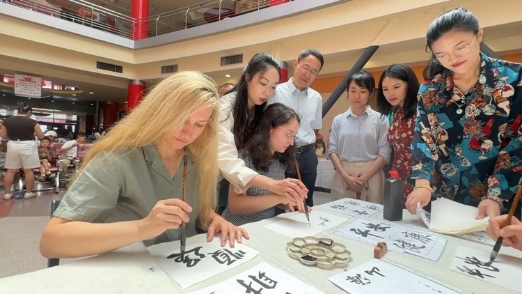羅馬尼亞友人在活動(dòng)現(xiàn)場(chǎng)學(xué)寫(xiě)漢字。中國(guó)駐羅馬尼亞大使館領(lǐng)僑處供圖