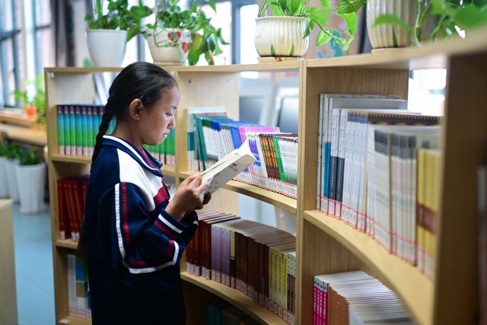 6月18日，果洛西寧民族中學學生尼東拉毛在圖書室看書。