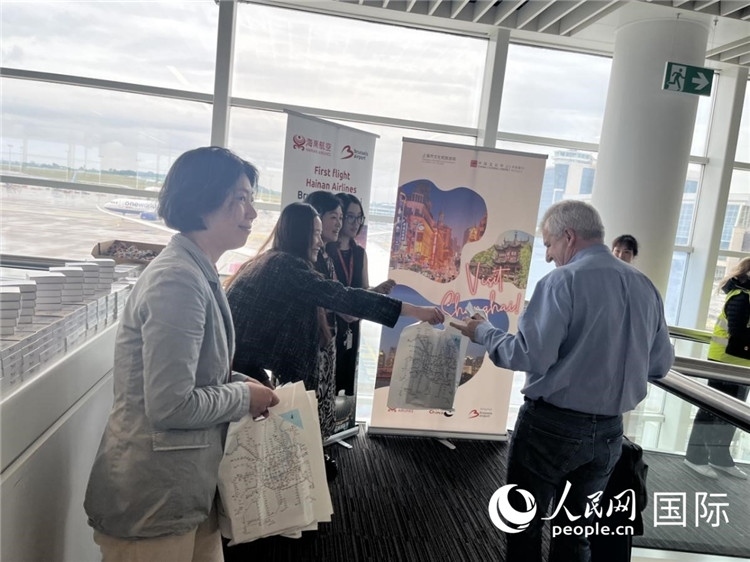 圖為工作人員向乘客發(fā)放復(fù)航首班禮物。 牛瑞飛攝