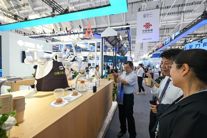 6月20日，與會(huì)者品嘗機(jī)器人沖調(diào)出的咖啡。新華社記者 孫凡越 攝