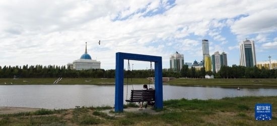 6月30日，一名女子在哈薩克斯坦首都阿斯塔納伊希姆河畔休息。新華社記者 王建華 攝