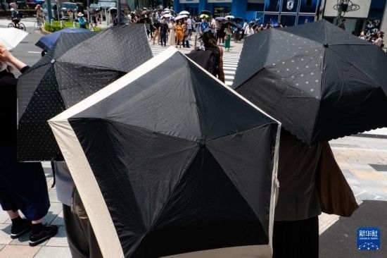 7月4日，人們在日本東京原宿的街道上等待紅綠燈。新華社記者 張笑宇 攝