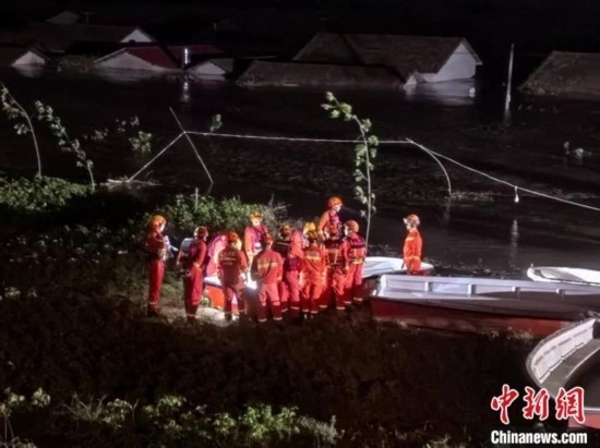  7月6日凌晨3時(shí)，在湖南岳陽華容縣團(tuán)洲垸洞庭湖一線堤防，救援人員剛剛完成一次救援任務(wù)，遠(yuǎn)處是被淹的民房。中新社記者 白祖偕 攝