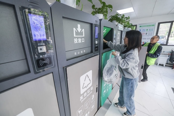 2024年4月10日，在浙江省湖州市吳興區(qū)飛英街道新華府小區(qū)內(nèi)，居民在垃圾分類智能系統(tǒng)的指導(dǎo)下進行垃圾分類投放，居民的投放情況將實時匯總到智慧服務(wù)平臺，會有相應(yīng)的積分獎勵。新華社記者 徐昱 攝