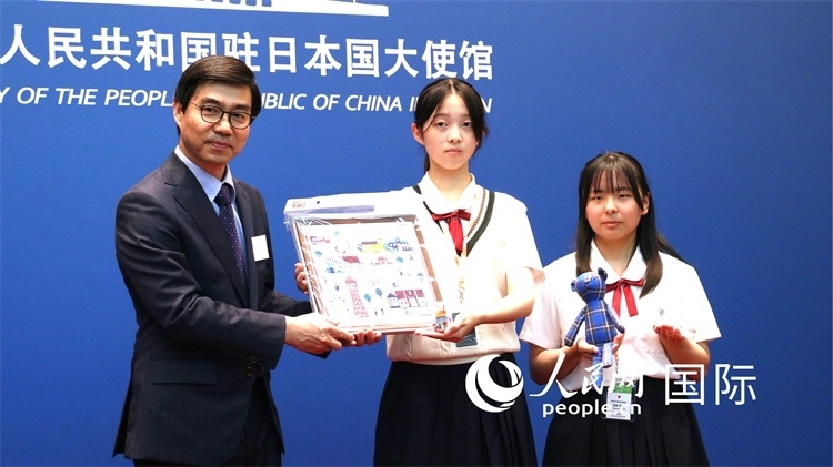 日本小大使向中國駐日本大使館臨時代辦施泳贈送當(dāng)?shù)靥厣Y品。人民網(wǎng) 許可攝