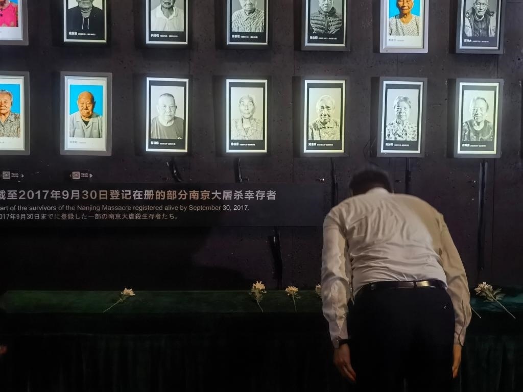 7月18日，人們向離世的南京大屠殺幸存者獻(xiàn)花、鞠躬。新華社記者邱冰清 攝