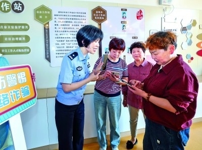 浙江湖州民警指導(dǎo)居民加入湖州“e企安”微信群，實(shí)時(shí)接收反詐信息。新華社發(fā)