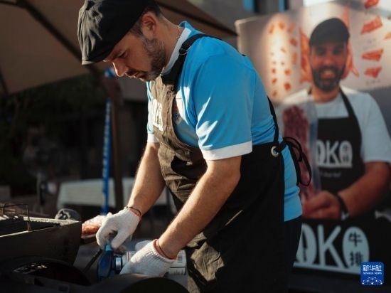 7月19日，在蕪湖古城，馬丁在當(dāng)天舉行的啤酒節(jié)上制作牛排。新華社發(fā)（繆雨晨 攝）