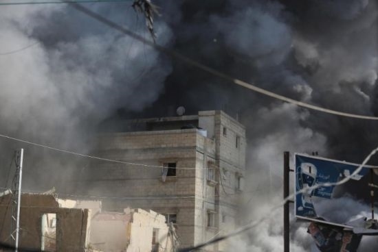 7月21日，在加沙地帶中部的努賽賴特難民營(yíng)，遭以軍空襲的建筑冒出滾滾濃煙。新華社發(fā)（馬爾萬(wàn)·達(dá)烏德攝）