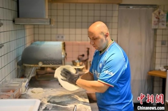 近日，韋榮耀在自家披薩小店內(nèi)忙活。俞靖 攝