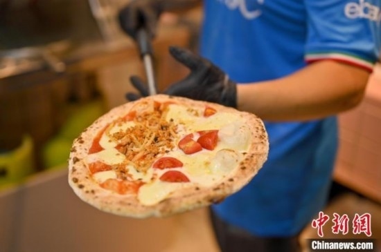 近日，韋榮耀展示他制作的“老友味”披薩。 俞靖 攝