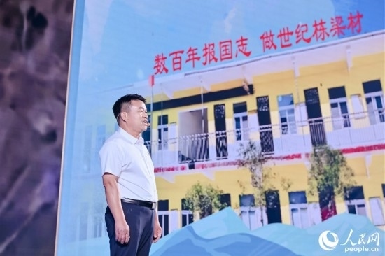 張玉滾分享用一根扁擔(dān)送孩子們走出大山的故事。人民網(wǎng)攝