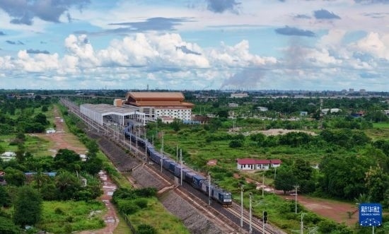 8月5日，由老撾籍火車司機(jī)獨(dú)立駕駛的滿載貨物的列車駛出萬象站，向中國昆明進(jìn)發(fā)（無人機(jī)照片）。新華社發(fā)（楊永全 攝）