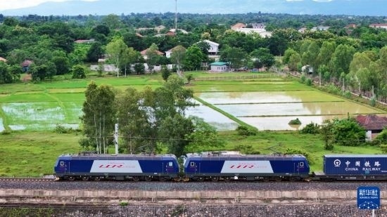 8月5日，由老撾籍火車司機(jī)獨(dú)立駕駛的滿載貨物的列車駛出萬象站，向中國昆明進(jìn)發(fā)（無人機(jī)照片）。新華社發(fā)（楊永全 攝）