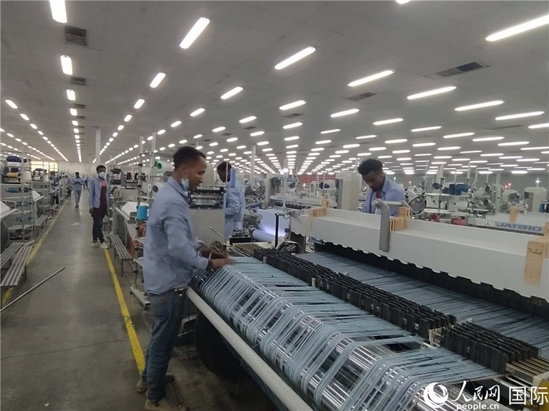 無(wú)錫金茂埃塞面料廠車間內(nèi)，當(dāng)?shù)毓と苏谝唤z不茍地作業(yè)。人民網(wǎng)記者 黃培昭攝