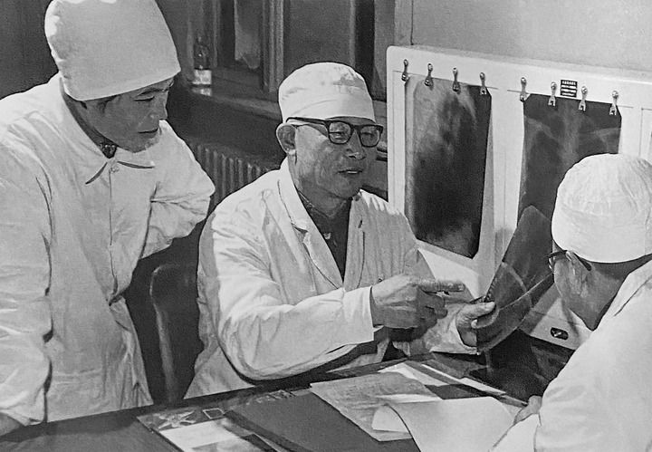 1980年1月16日，中日友好醫(yī)院首任院長(zhǎng)辛育齡（中）在內(nèi)蒙古結(jié)核病院與胸外科醫(yī)師討論病例（翻拍照片）。 新華社發(fā)