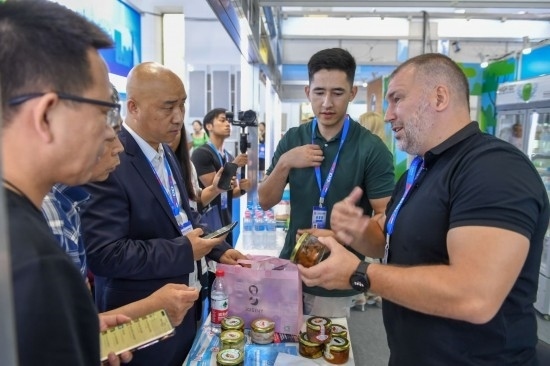 2023年8月23日，在第十四屆中國—東北亞博覽會東北亞商品館，俄羅斯參展商向參觀者介紹商品。