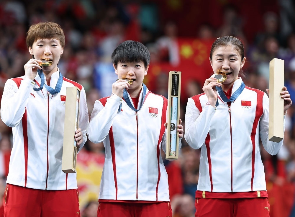 冠軍中國隊(duì)選手王曼昱、孫穎莎、陳夢（從左至右）在巴黎奧運(yùn)會(huì)乒乓球女子團(tuán)體頒獎(jiǎng)儀式上（2024年8月10日攝）。新華社記者 王東震 攝